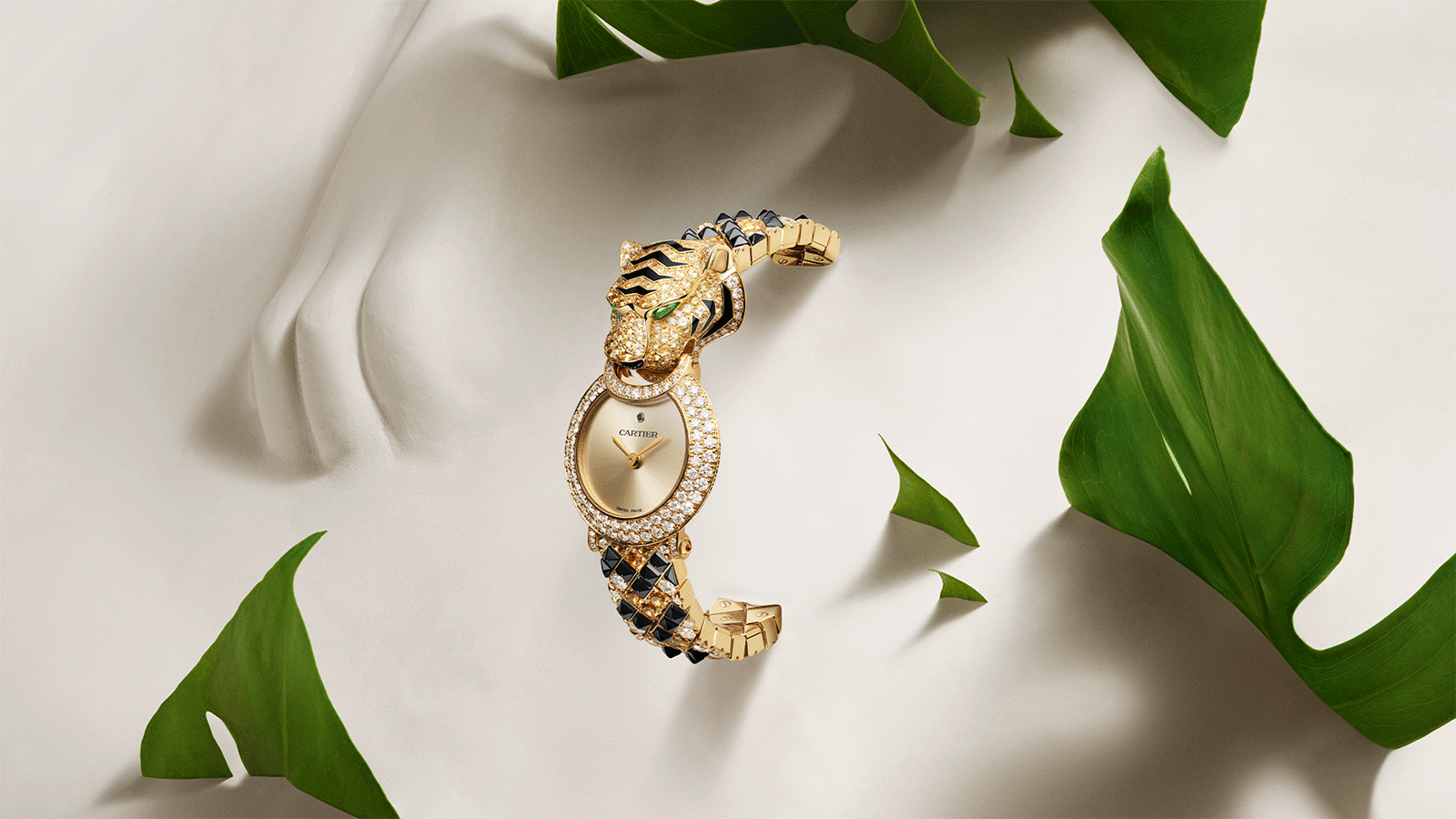 Cartier's Animal Jewelry timepiece featuring a tiger motif and a bracelet adorned with gemstones.