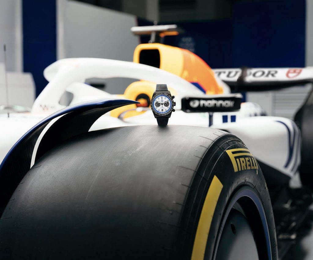 TUDOR Black Bay Chrono Carbon 25 positioned next to a Formula One racing car tyre